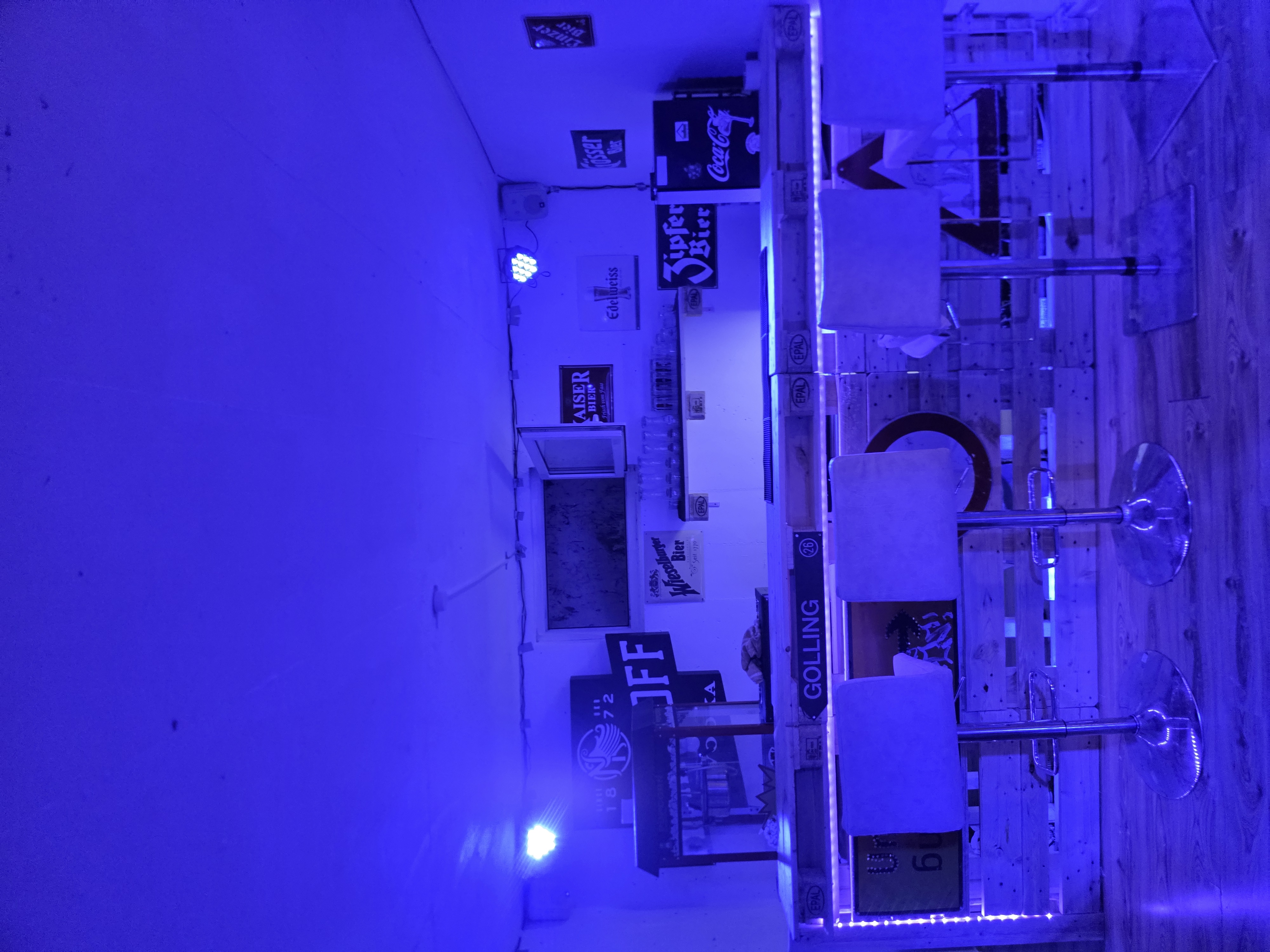 Unsere selbst gebaute Theke im Keller, blau beleuchtet mit Bierkrügen und Gläsern
